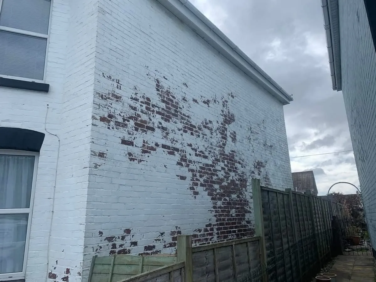 Peeling paint on a brick wall before redecoration in Dartmouth