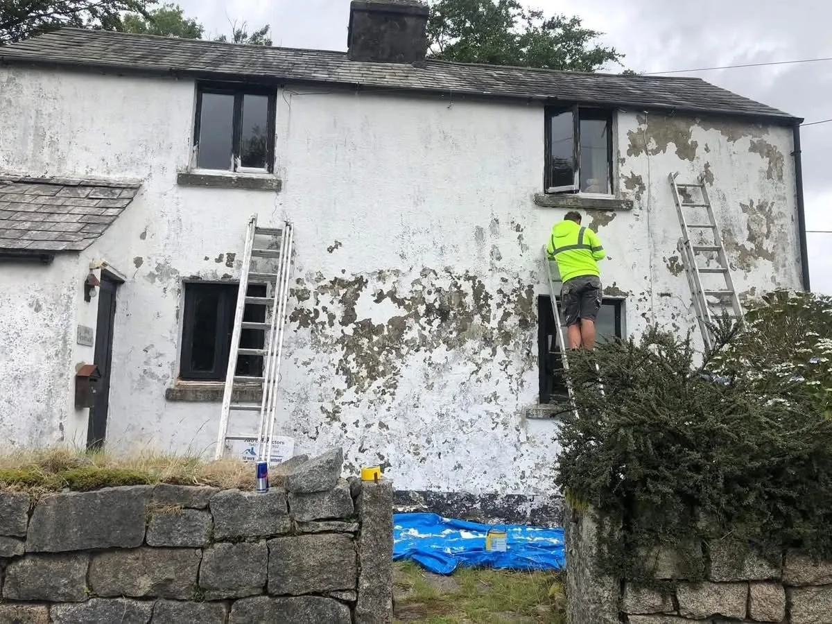 Cottage with blown, flaking render before repair in Dartmouth